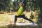 Fun girl exercising outdoors in green forest, activity with stretch legs, fitness stretching exercises training outside