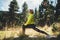 Fun girl one exercising outdoors in green forest sun summer day, activity with stretch legs. Smile fitness woman stretching