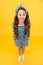 Fun lifestyle little girl long hair denim overalls, cheerful grimace concept