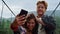 Fun lovers make photo on smartphone selfie travel blog. Couple kiss in mountains