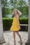 Fun photo of yong blonde woman in yellow dress twirling around