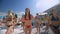 Fun by the pool, young women relaxing in swimsuits at a luxury resort have fun repeating dances on morning exercises
