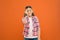 Fun Valentines props. Cute kid smiling with fancy party props on orange background. Funny small girl holding heart