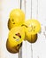 Fun, yellow emoji balloons bunched together in the sun