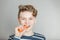 Fun young boy biting into a fresh raw carrot