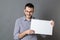 Fun young man holding a copy space banner to tease