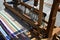 Functional historical wooden hand-loom weaving colorful mat with vertical lines displayed on festival of medieval and traditional