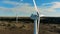 Functioning windmills, wind energy turbines installed in the open terrain. Green energy concept.