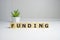 FUNDING word on wooden background composed from colorful abc alphabet block wooden letters, copy space for ad text. Learning