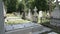 Funeral gothic girl walking beside tombstones in an ancient graveyard contemplating death and solitude