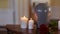 Funerary urn and candles on table burning indoors
