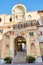 Funicular station entrance with beige facade and virgin Mary statue in Mondovi, Italy