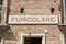 Funicular station entrance sign in red bricks wall in a sunny day in Mondovi, Italy