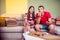 Funky young couple eating pizza on a couch