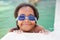 Funny afroamerican girl with goggles in the pool