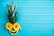 Funny applique from pieces of fruit on a turquoise wooden background. Fruit head made of pineapple, orange, copy space