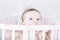 Funny baby biting on a crib