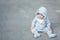 Funny baby boy on knees trying to walk. Awesome infant kid. Smiling toddler and his first steps