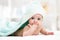 Funny baby child under a hooded towel after bath