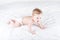 Funny baby crawling on a white bed