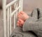 Funny baby feet out of gray pants on cot