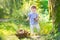 Funny baby girl gathering mushrooms in an autumn park