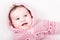 Funny baby girl in pink jacket with hearts pattern