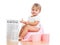 Funny baby girl reading newspaper on chamberpot