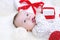 Funny baby lying with gift in hands