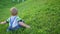 Funny baby playing on the grass. Rolling down from the slope. Fun outdoors