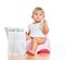 Funny baby sitting on chamberpot with newspaper