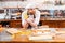 Funny baker making moustache using macarons on the kitchen