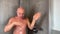 Funny bald middle-aged man washes in the shower and dances, expressively dancing