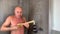 Funny bald middle-aged man washes in the shower and expressively depicts playing the guitar