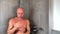 Funny bald middle-aged man washes in the shower and expressively depicts playing musical instruments