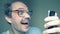 Funny balding man in glasses uses a smartphone and smiles