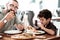 Funny beaming son feeling happy eating cheesy pizza with father