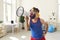 Funny bearded male trainer loudly shouts into a loudspeaker urging everyone to do exercises.