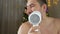 A funny bearded man sings and holds a hairdryer, and dries his beard with a hairdryer against the background of the New