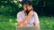 Funny bearded man working with a laptop in the park. Freelance or telework, online chatting concept.