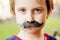 Funny beautiful little child girl wearing fake mustaches. Ready