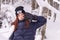 Funny beauty attractive woman with winter fashion clothing is making funny face in snow skii resort woodland