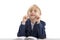 Funny blond boy in big glasses wears jacket or school uniform sitting at desk and smiling at the camera. Isolated on white