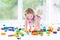 Funny blond toddler girl sitting on floor in mess