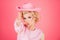 Funny blonde woman with pink cowboy hat. Young american cowgirl woman portrait.