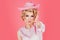 Funny blonde woman with pink cowboy hat. Young american cowgirl woman portrait.