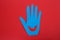 Funny blue hand shaped monster on red background, top view. Halloween decoration