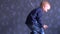 Funny boy in blue clothes is playing with red balloon against gray wall. Child is happy at home