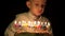 Funny boy eyes looking anxious behind cake, child blowing birthday candles