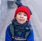 Funny boy in full winter clothing walking on the street